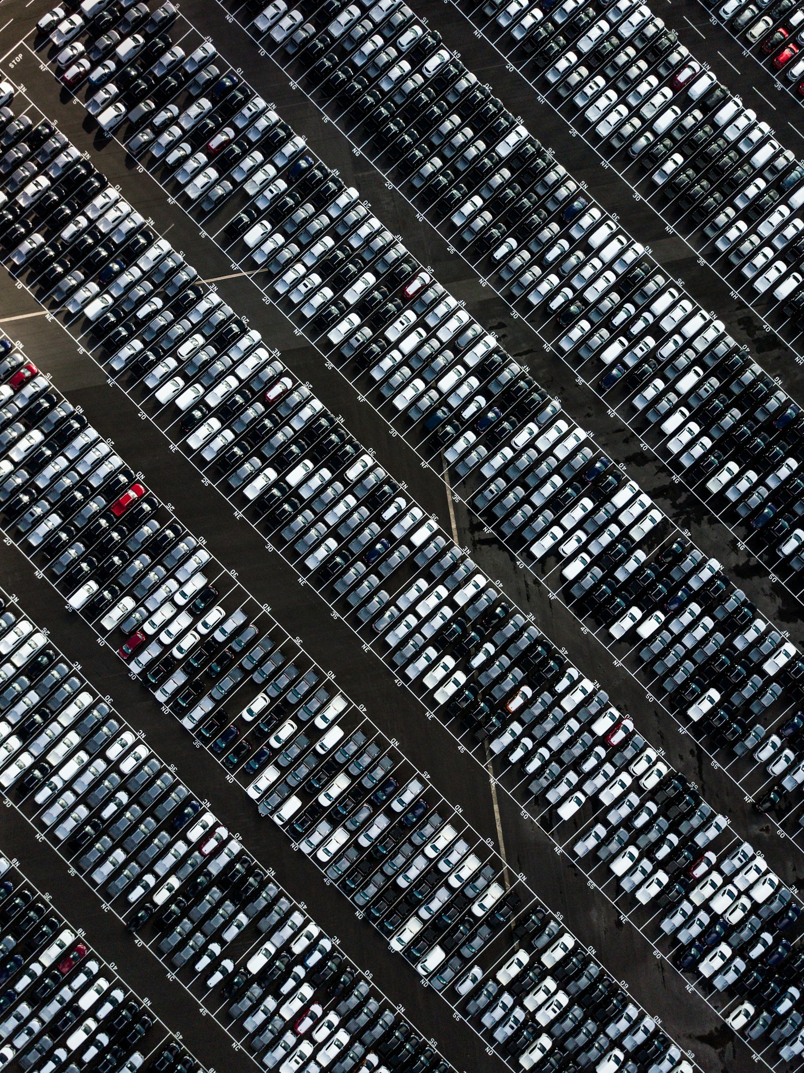 Overhead view of rows of used cars parked tightly in a dealership lot